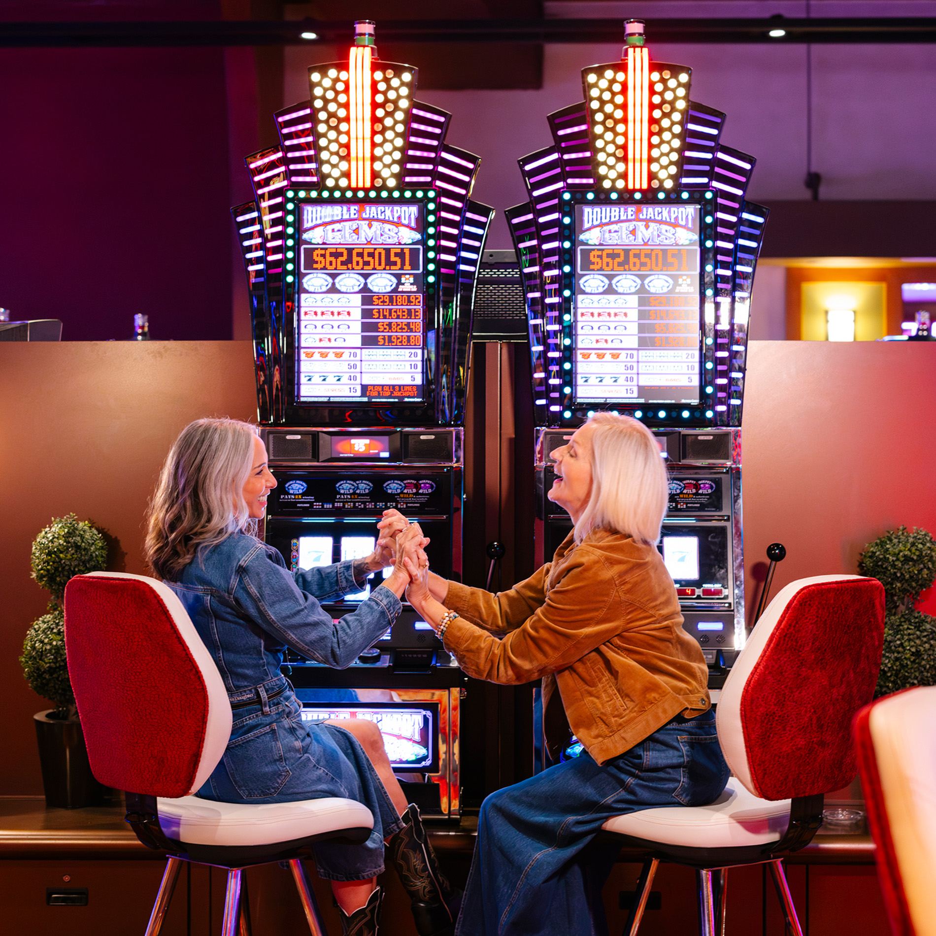 two ladies at slot machines in a casino