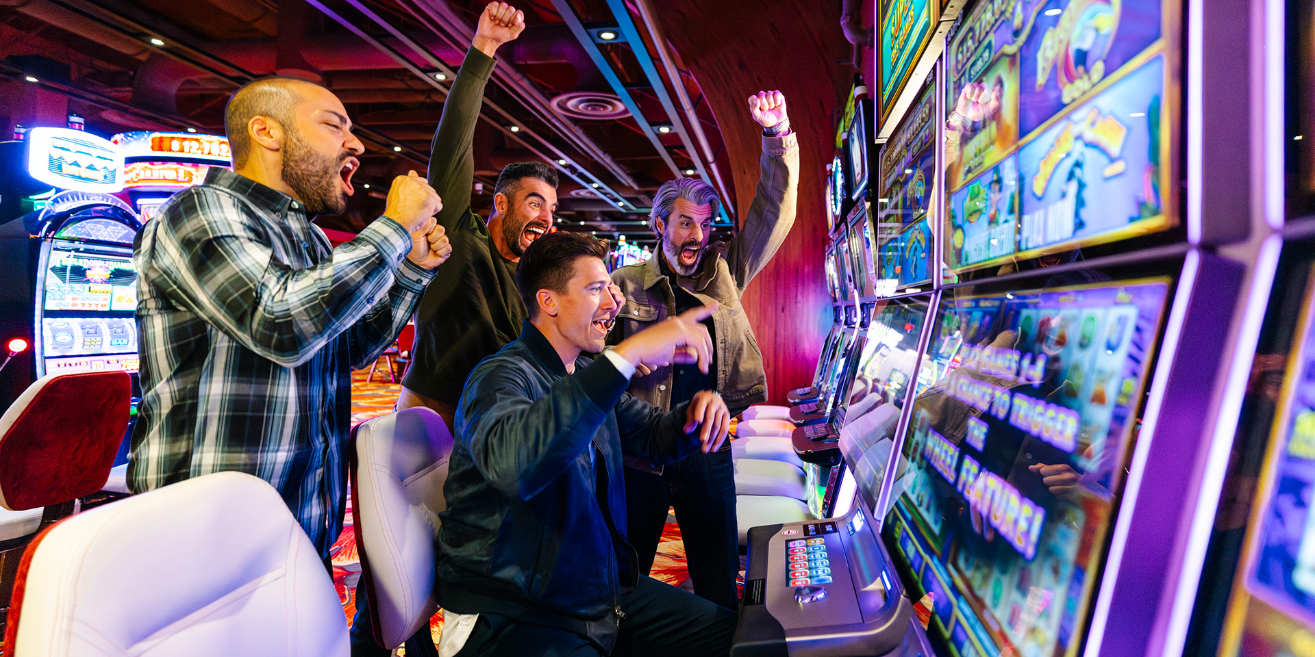 four male friends cheering for a jackpot at a slot machine